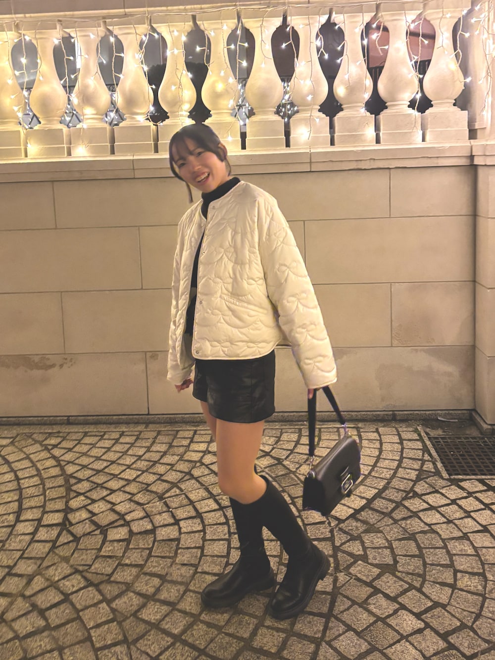 ホワイト系のその他アウター、ブラック系のその他パンツ、ブラック系のブーティを着用したレディースの冬コーディネートの1枚目の写真