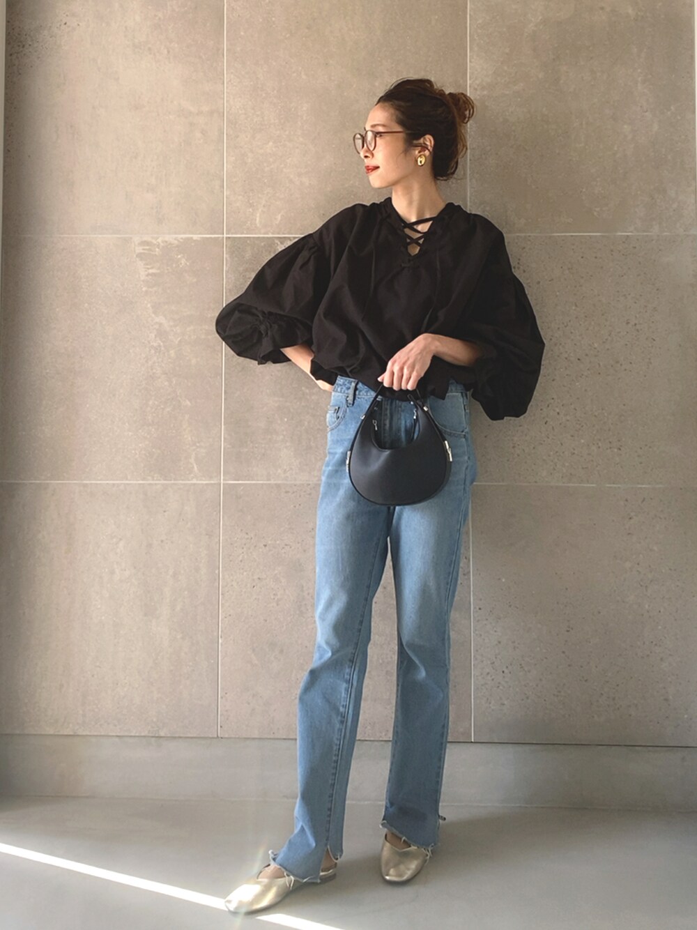 ブラック系のシャツ/ブラウス、ブラック系のハンドバッグ、ブラック系のデニムパンツを着用したレディースの春コーディネートの1枚目の写真