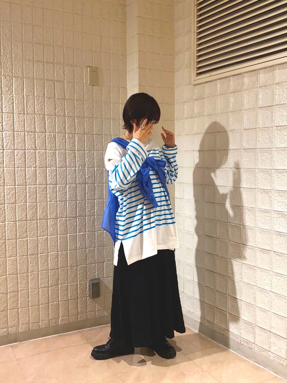 ブルー系のシャツ/ブラウス、ホワイト系のTシャツ/カットソー、ブラック系のスカートを着用したレディースの春コーディネートの1枚目の写真