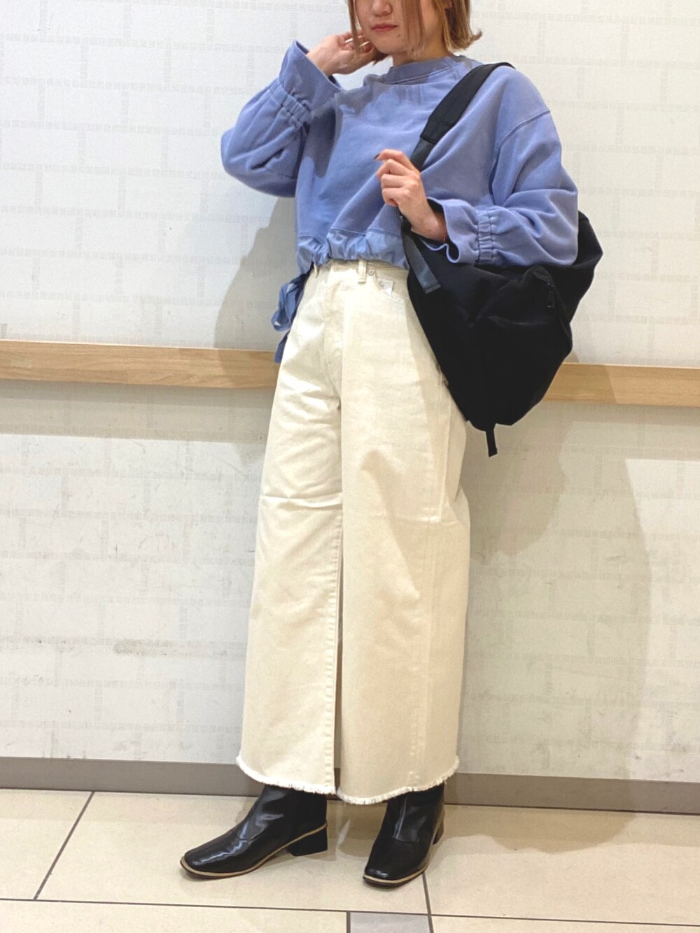 ホワイト系のデニムパンツ、ブラック系のバックパック/リュック、ブルー系のTシャツ/カットソーを着用したレディースの冬コーディネートの1枚目の写真