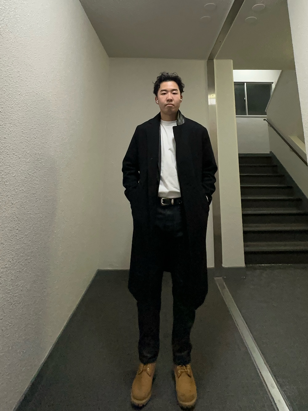 ブラック系のジャケット/アウター、ブラック系のパンツ、イエロー系のブーツを着用したメンズの冬コーディネートの1枚目の写真