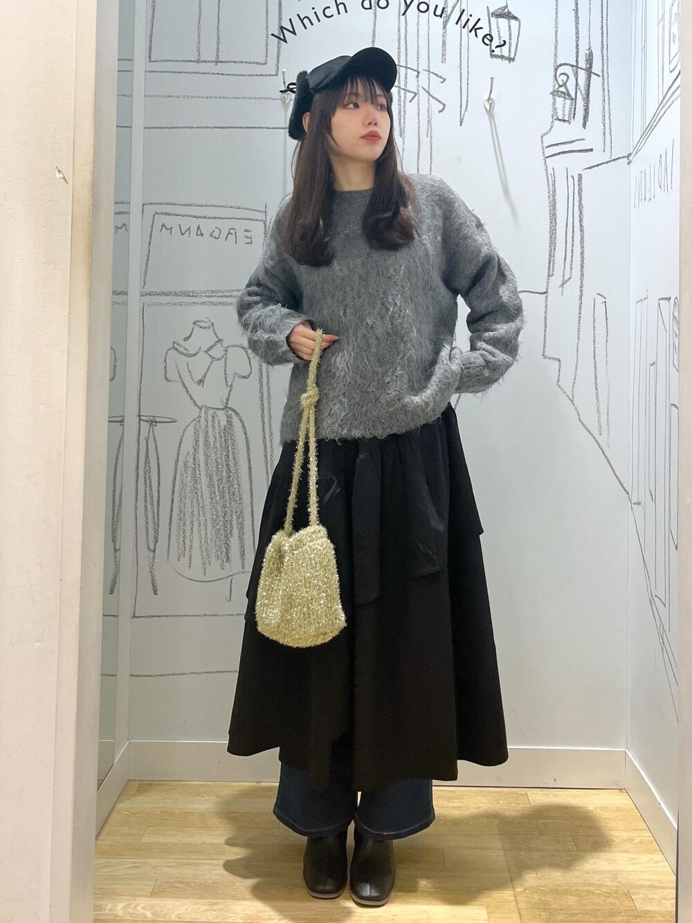 ブルー系のデニムパンツ、ブラック系のブーツ、ブラック系のスカートを着用したレディースの冬コーディネートの1枚目の写真