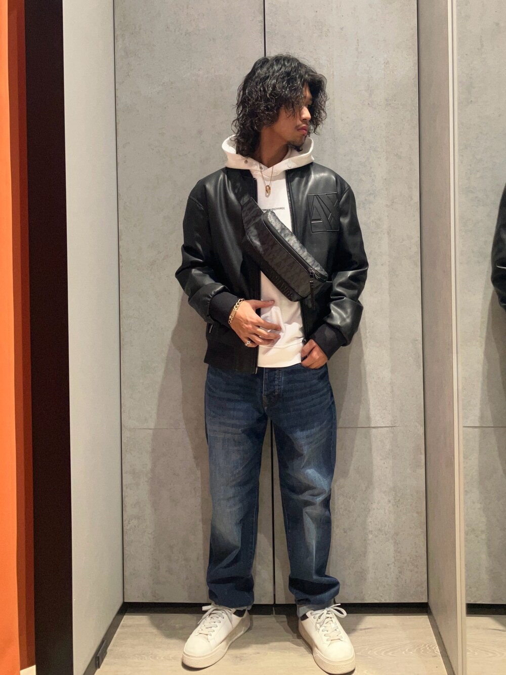 ホワイト系のスニーカー、ブルー系のデニムパンツ、ブラック系のブルゾンを着用したメンズの冬コーディネートの1枚目の写真