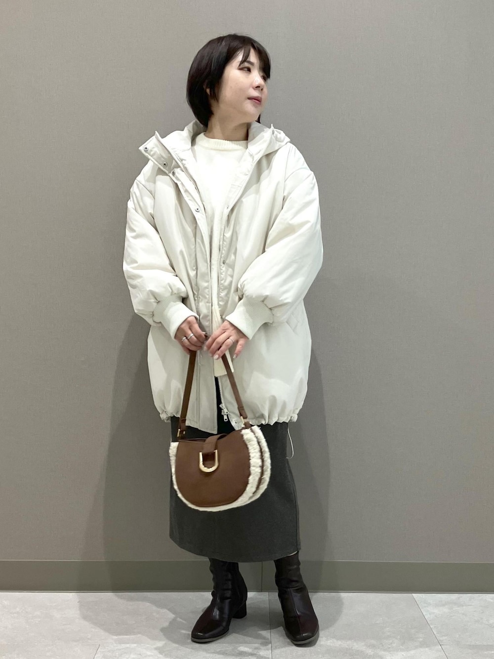 ホワイト系のニット/セーター、ブラウン系のショルダーバッグ、ブラウン系のスカートを着用したレディースの秋コーディネートの1枚目の写真