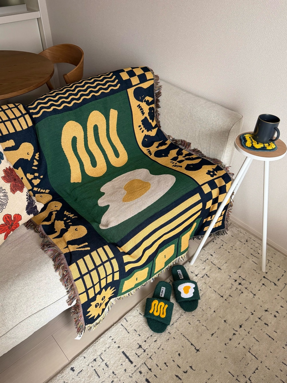 グリーン系のブランケット、グリーン系のルームシューズ/スリッパ、ホワイト系の家具を着用したレディースの春コーディネートの1枚目の写真