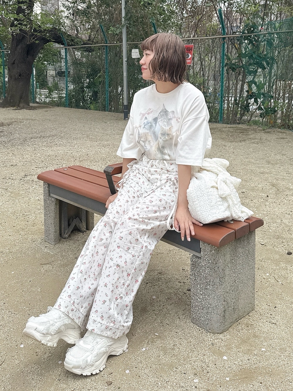 ホワイト系のTシャツ/カットソー、ホワイト系のスラックス、ホワイト系のトートバッグを着用したレディースの春コーディネートの1枚目の写真