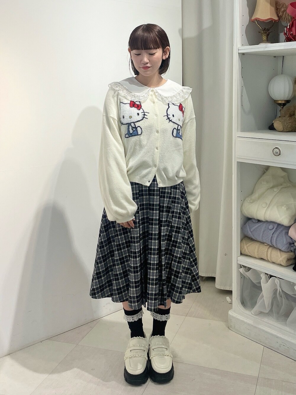 ホワイト系のカーディガン/ボレロ、シルバー系のシャツ/ブラウス、ブラック系のスカートを着用したレディースの秋コーディネートの1枚目の写真