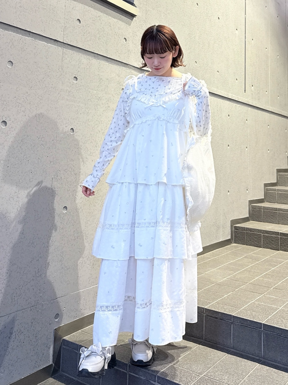 ブルー系のTシャツ/カットソー、ホワイト系のワンピース、ホワイト系のトートバッグを着用したレディースの冬コーディネートの1枚目の写真