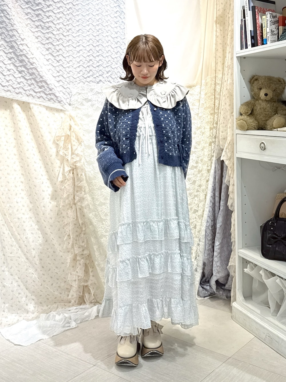 ブルー系のカーディガン/ボレロ、グレー系のシャツ/ブラウス、ブルー系のワンピースを着用したレディースの秋コーディネートの1枚目の写真