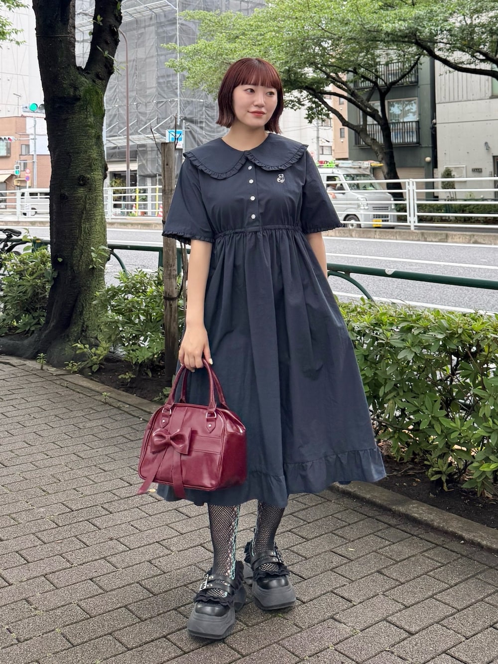 ブルー系のワンピース、レッド系のハンドバッグ、ブラック系のスニーカーを着用したレディースの夏コーディネートの1枚目の写真