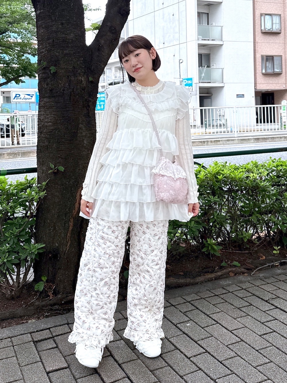 ホワイト系のシャツ/ブラウス、ホワイト系のニット/セーター、ピンク系のハンドバッグを着用したレディースの夏コーディネートの1枚目の写真