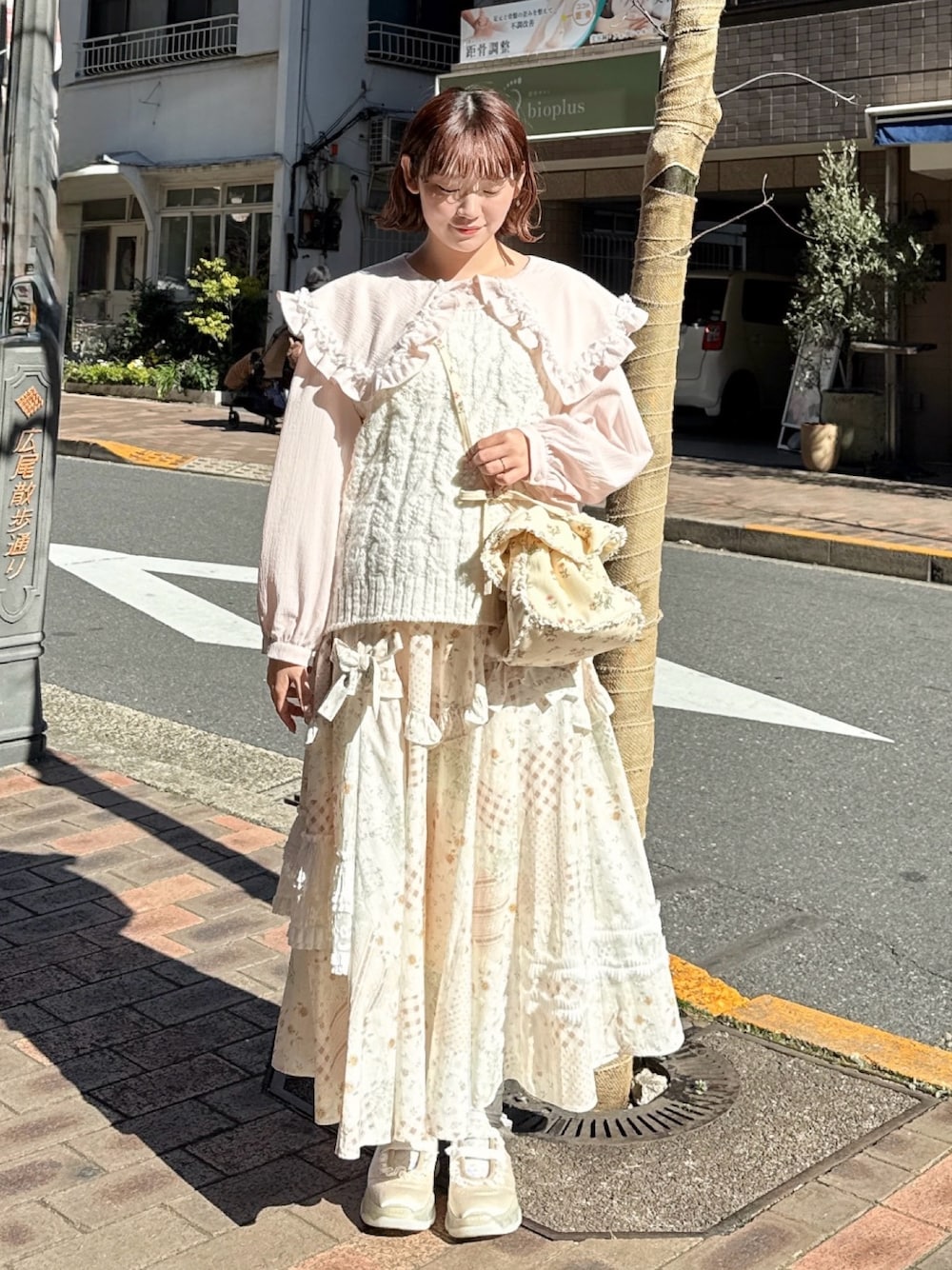 ピンク系のシャツ/ブラウス、ホワイト系のスカート、ホワイト系のショルダーバッグを着用したレディースの冬コーディネートの1枚目の写真