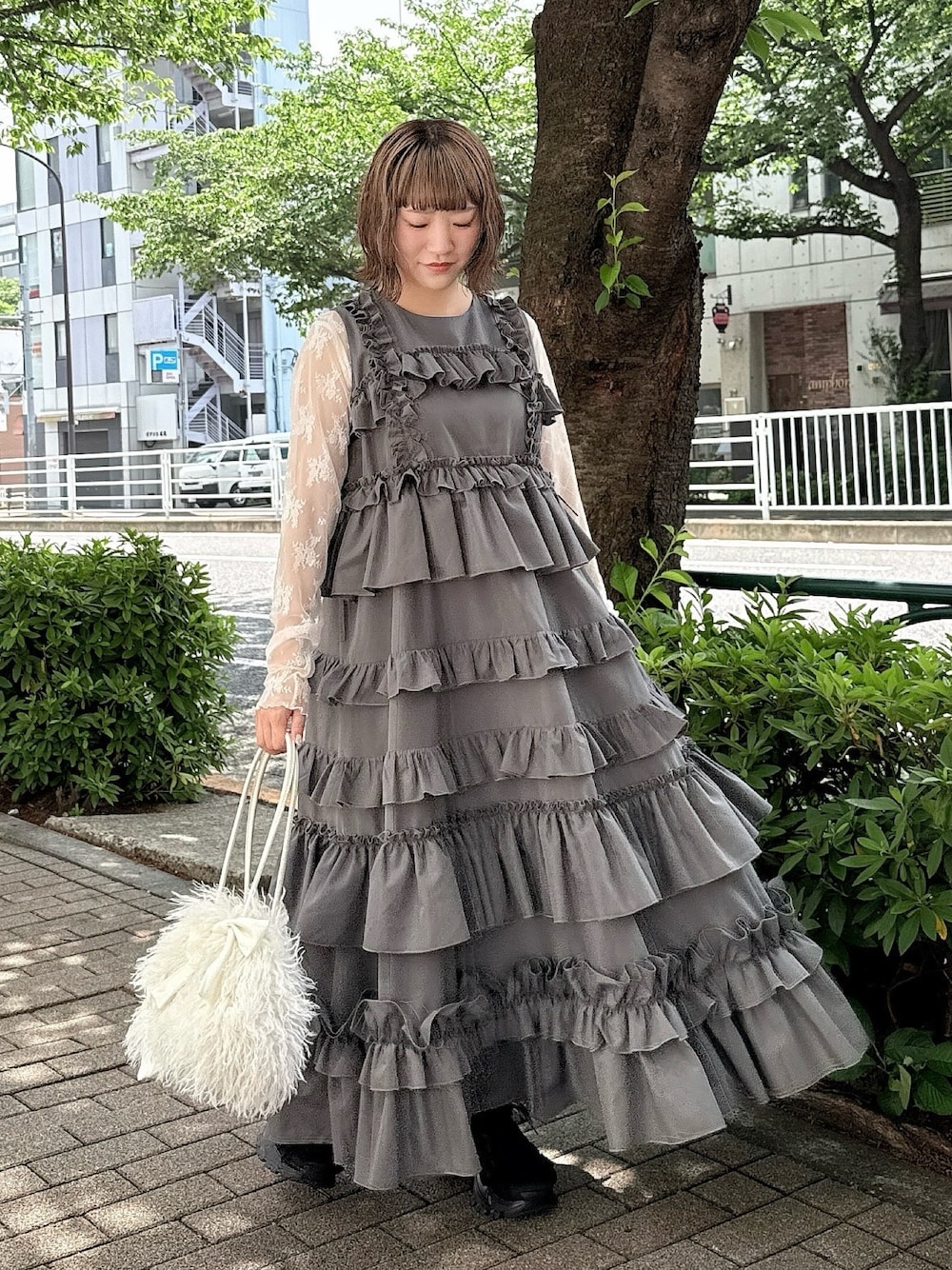 グレー系のワンピース、ホワイト系のTシャツ/カットソー、ホワイト系のボストンバッグを着用したレディースの春コーディネートの1枚目の写真