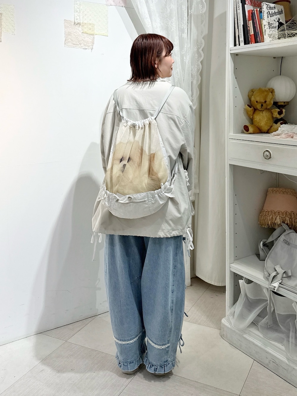 ホワイト系のブルゾン、ホワイト系のバックパック/リュック、ブルー系のデニムパンツを着用したレディースの冬コーディネートの1枚目の写真