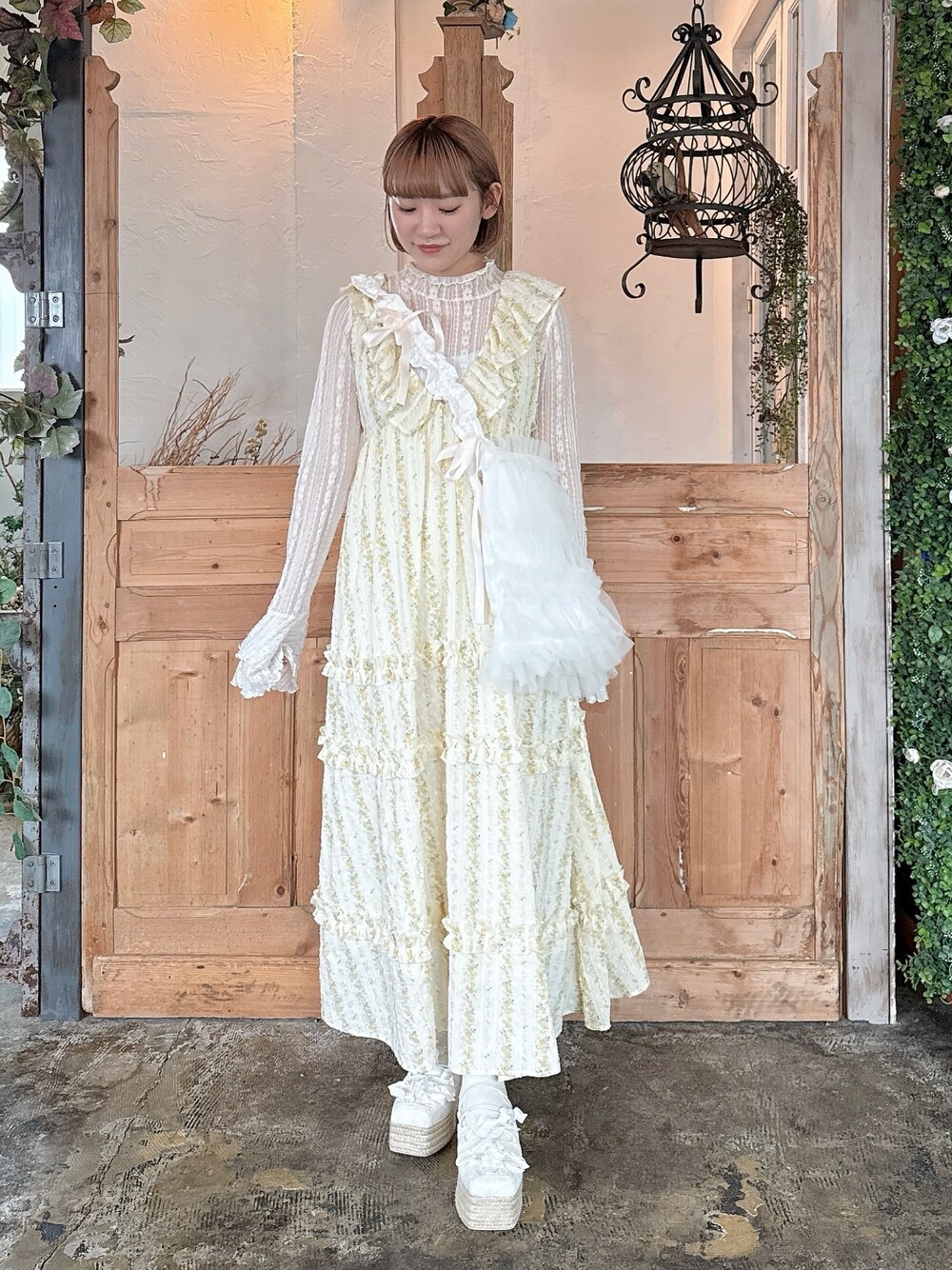 イエロー系のワンピース、ホワイト系のTシャツ/カットソー、ホワイト系のトートバッグを着用したレディースの春コーディネートの1枚目の写真
