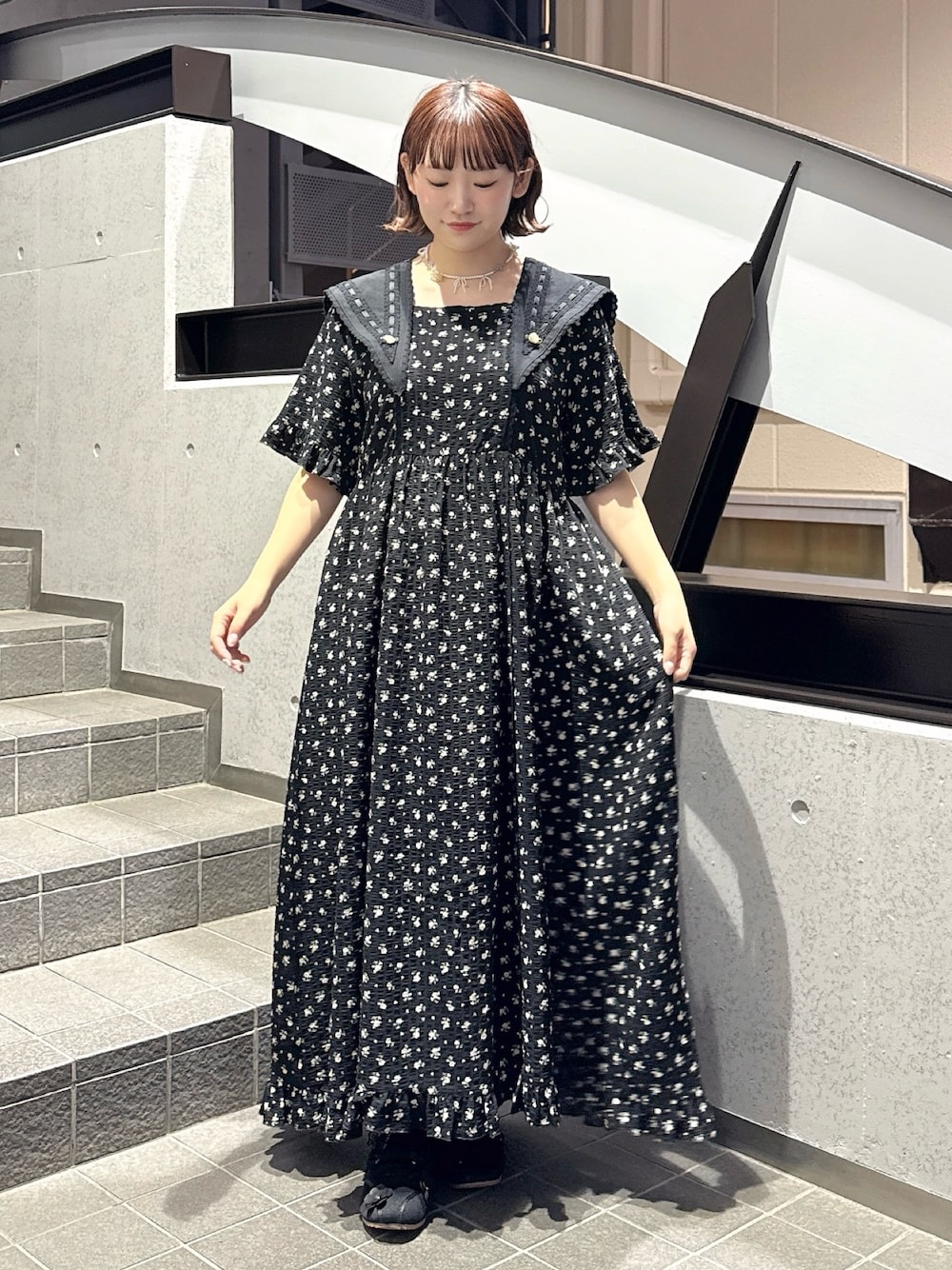 ブラック系のワンピース、ブラック系のスニーカー、ピンク系のネックレスを着用したレディースの春コーディネートの1枚目の写真