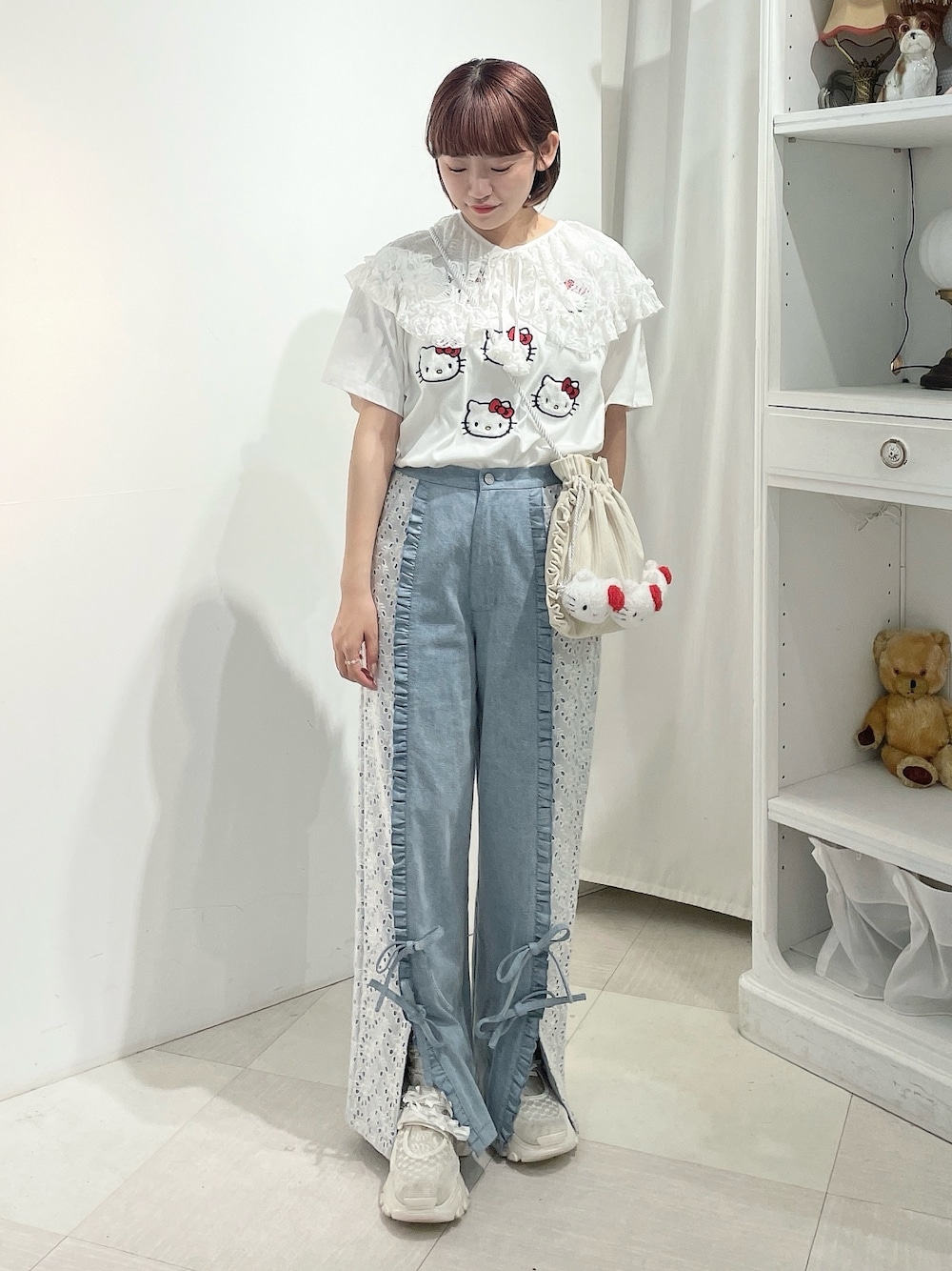 ブルー系のデニムパンツ、ホワイト系のスニーカー、ホワイト系のショルダーバッグを着用したレディースの春コーディネートの1枚目の写真