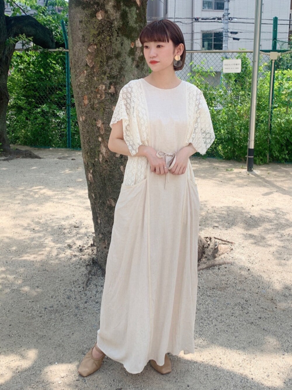 ベージュ系のパンプス、ホワイト系のワンピースを着用したレディースの春コーディネートの1枚目の写真