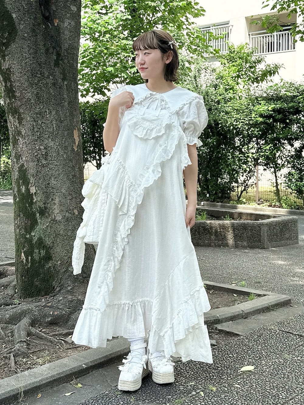 ホワイト系のシャツ/ブラウス、ホワイト系のサンダル、ホワイト系のトートバッグを着用したレディースの春コーディネートの1枚目の写真