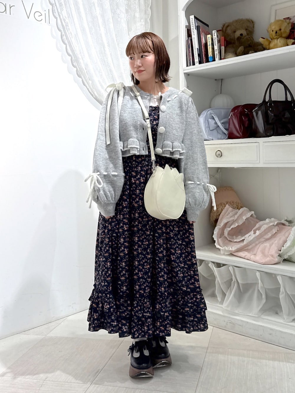 グレー系のカーディガン/ボレロ、ホワイト系のTシャツ/カットソー、ホワイト系のショルダーバッグを着用したレディースの秋コーディネートの1枚目の写真