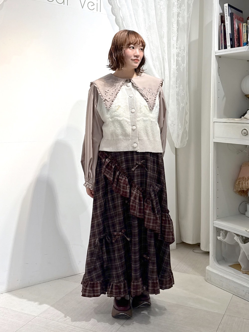 ベージュ系のシャツ/ブラウス、ピンク系のベスト、レッド系のスカートを着用したレディースの夏コーディネートの1枚目の写真