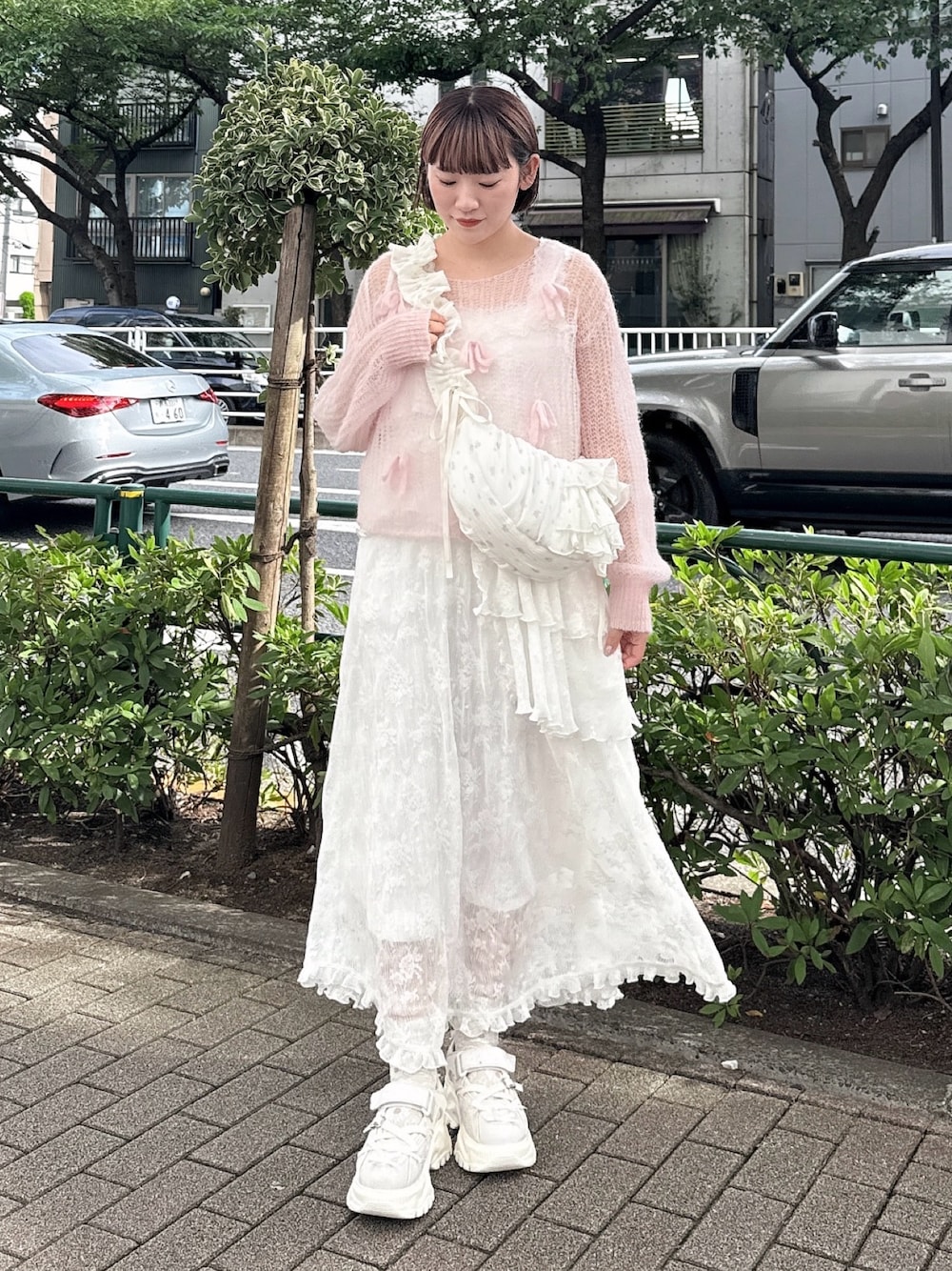 ピンク系のニット/セーター、ホワイト系のショルダーバッグ、ホワイト系のワンピースを着用したレディースの夏コーディネートの1枚目の写真