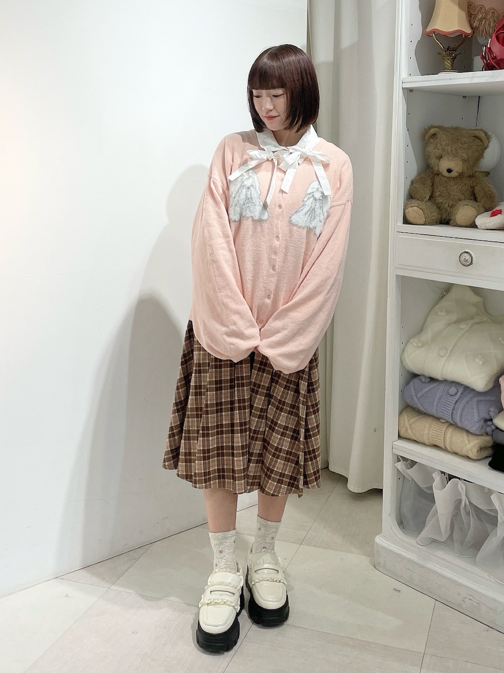 ホワイト系のシャツ/ブラウス、ピンク系のカーディガン/ボレロ、ブラウン系のスカートを着用したレディースの秋コーディネートの1枚目の写真