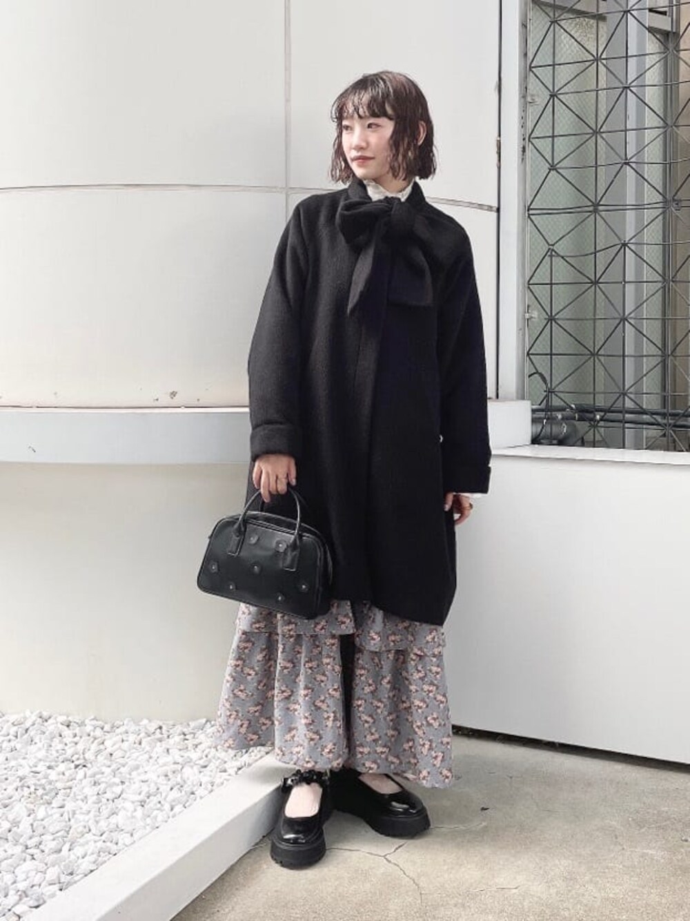 ブラック系のボストンバッグ、ブラック系のその他アウター、ブルー系のジャンパースカートを着用したレディースの夏コーディネートの1枚目の写真