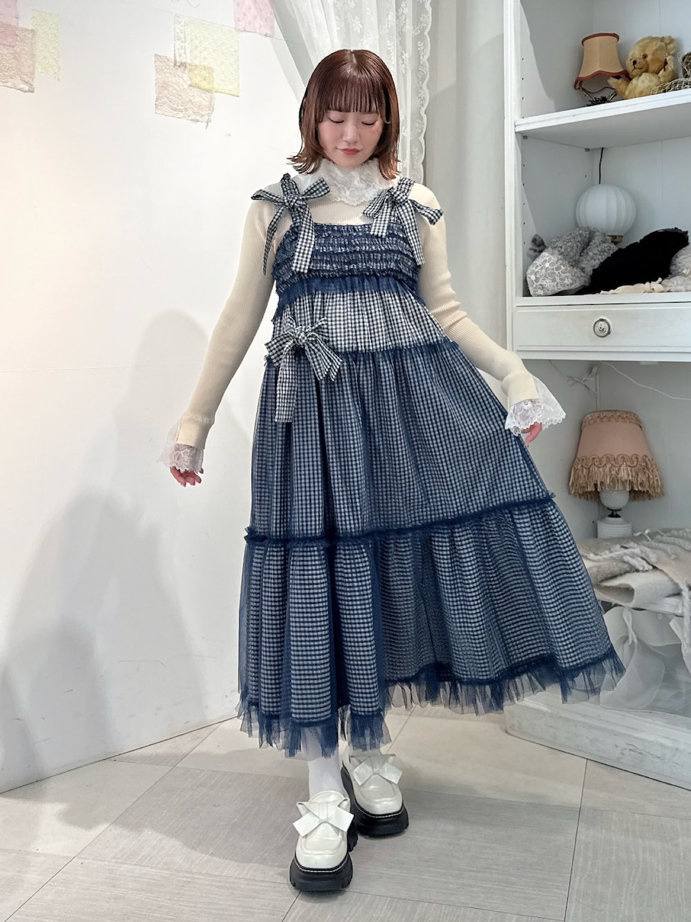 ホワイト系のニット/セーター、ブルー系のワンピース、ホワイト系のローファーを着用したレディースの冬コーディネートの1枚目の写真