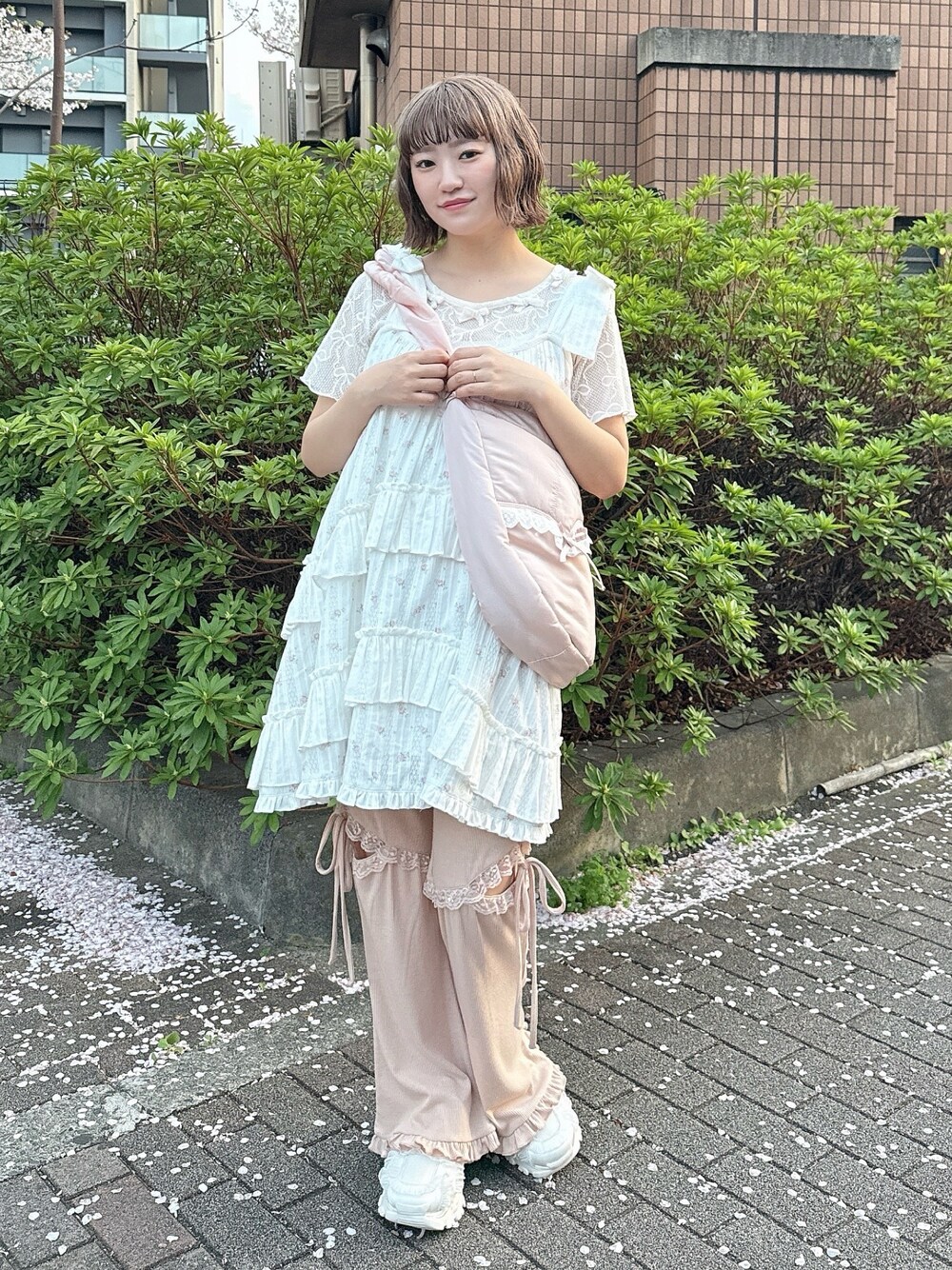 ピンク系のショルダーバッグ、ホワイト系のTシャツ/カットソー、ピンク系のワンピースを着用したレディースの春コーディネートの1枚目の写真