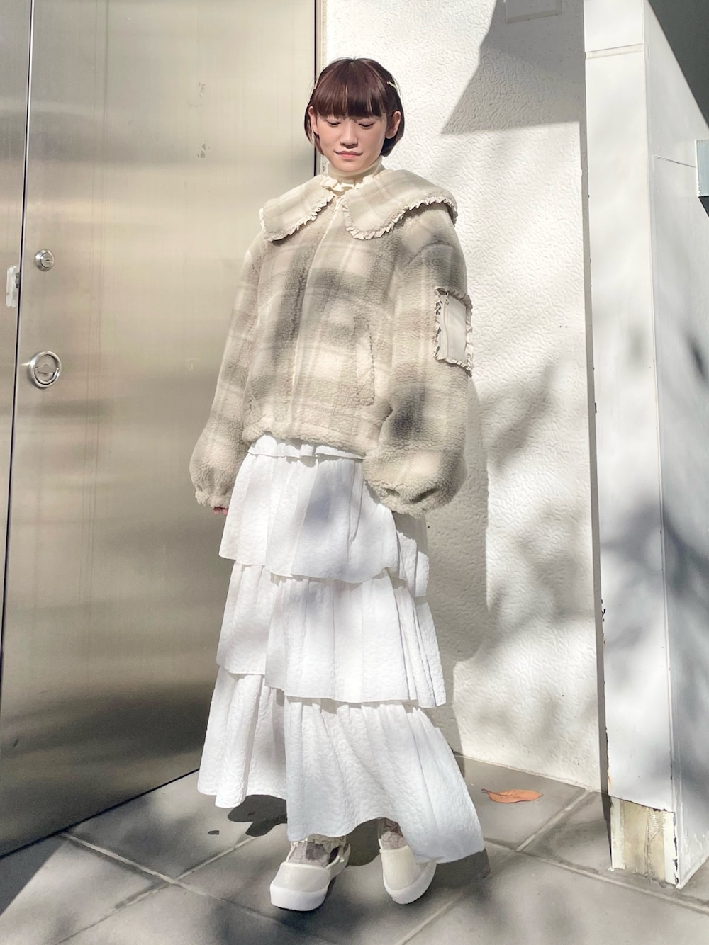 ホワイト系のスカート、ベージュ系のブルゾン、ホワイト系のニット/セーターを着用したレディースの冬コーディネートの1枚目の写真