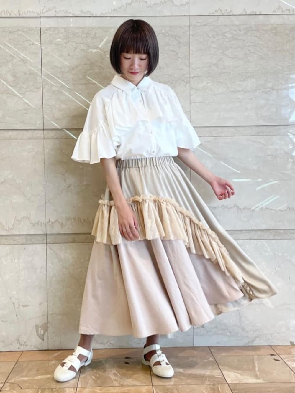 ホワイト系のスカート、ホワイト系のパンプスを着用したレディースの夏コーディネートの1枚目の写真