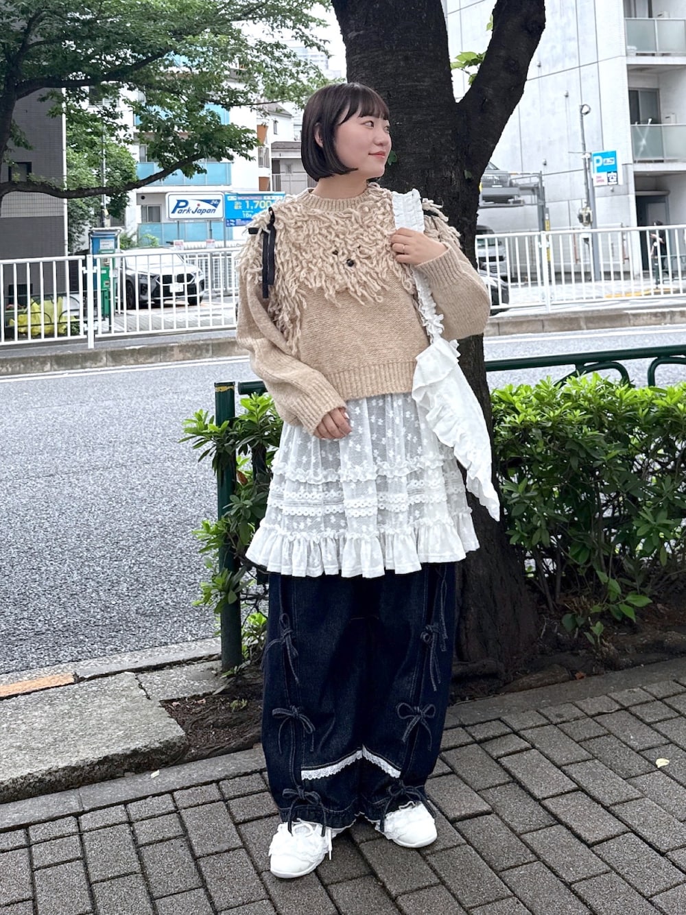ブルー系のデニムパンツ、ホワイト系のスニーカー、ホワイト系のスカートを着用したレディースの夏コーディネートの1枚目の写真