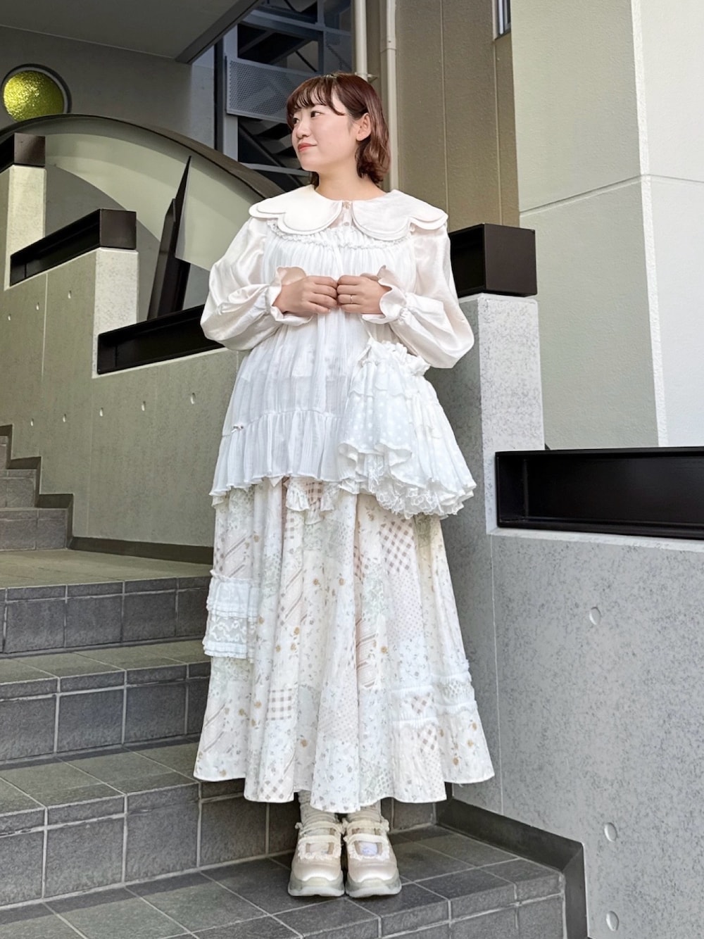 ピンク系のシャツ/ブラウス、ホワイト系のスカート、ホワイト系のショルダーバッグを着用したレディースの春コーディネートの1枚目の写真