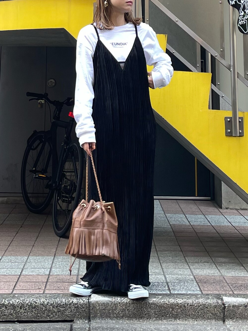 ブラック系のワンピース、ホワイト系のTシャツ/カットソー、ブラック系のスニーカーを着用したレディースの秋コーディネートの1枚目の写真