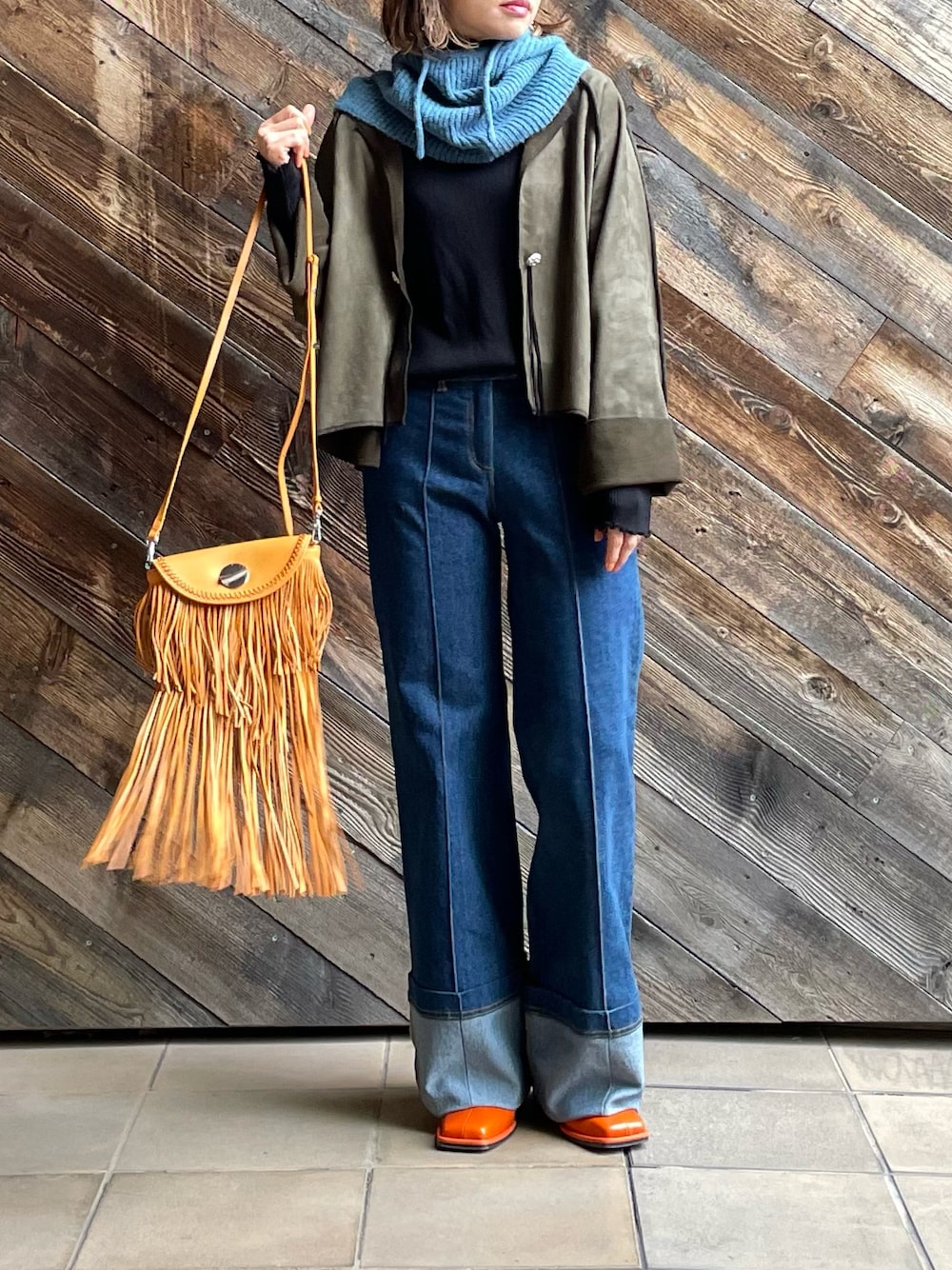 グリーン系のノーカラージャケット、ブルー系のネックウォーマー/スヌードを着用したレディースの秋コーディネートの1枚目の写真