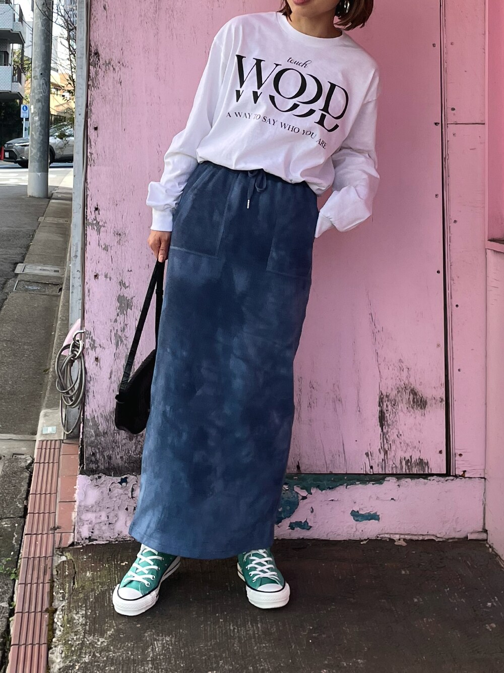 ブルー系のスカート、グリーン系のスニーカー、ホワイト系のTシャツ/カットソーを着用したレディースの春コーディネートの1枚目の写真