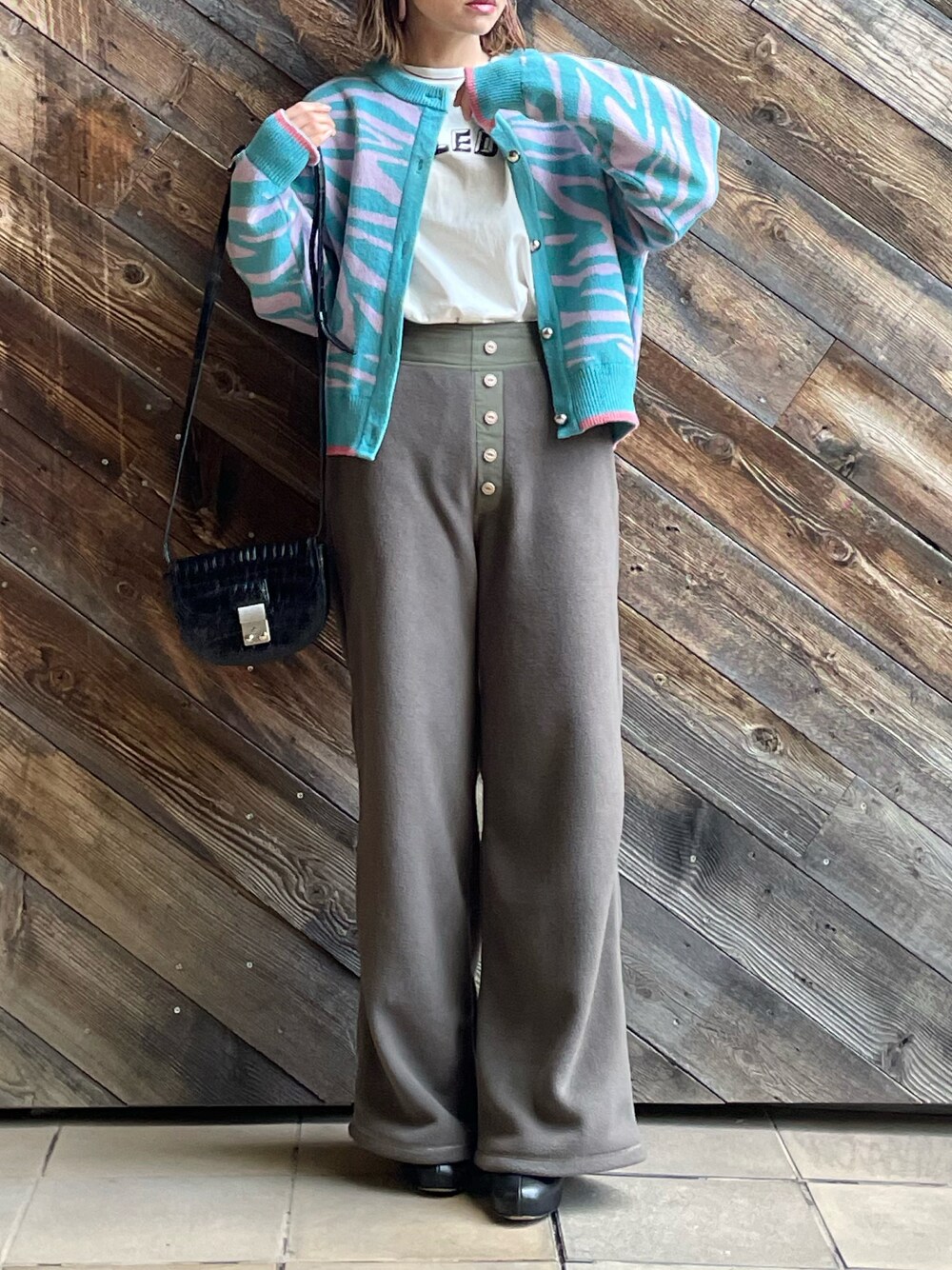 グレー系のその他パンツ、ブルー系のカーディガン/ボレロ、ホワイト系のTシャツ/カットソーを着用したレディースの冬コーディネートの1枚目の写真