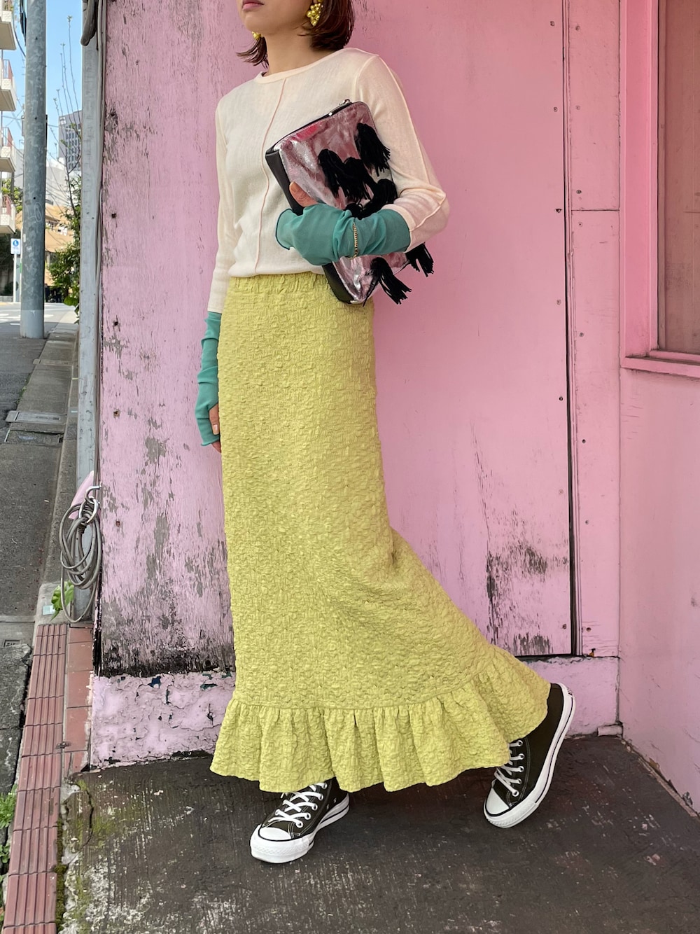 イエロー系のスカート、ベージュ系のTシャツ/カットソー、グリーン系のスニーカーを着用したレディースの春コーディネートの1枚目の写真