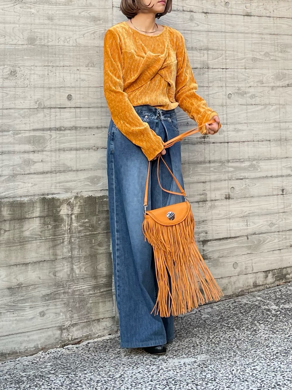 イエロー系のTシャツ/カットソーを着用したレディースの秋コーディネートの1枚目の写真