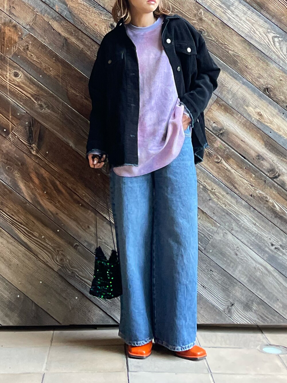 パープル系のTシャツ/カットソー、ブラック系のジャケット/アウター、ブルー系のデニムパンツを着用したレディースの冬コーディネートの1枚目の写真