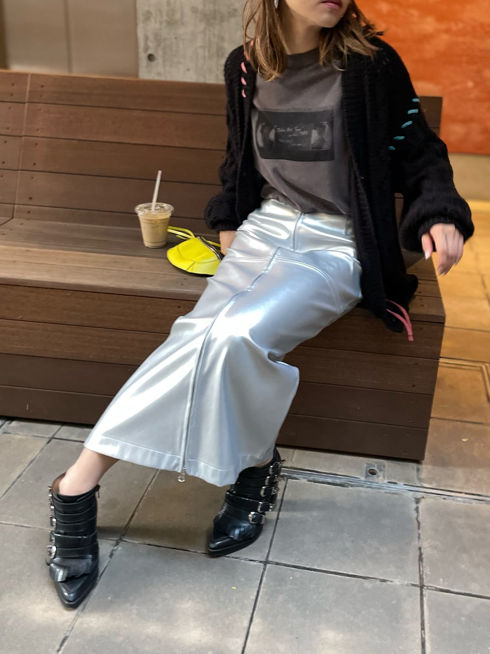 シルバー系のスカート、ブラック系のカーディガン/ボレロ、グレー系のTシャツ/カットソーを着用したレディースの秋コーディネートの1枚目の写真