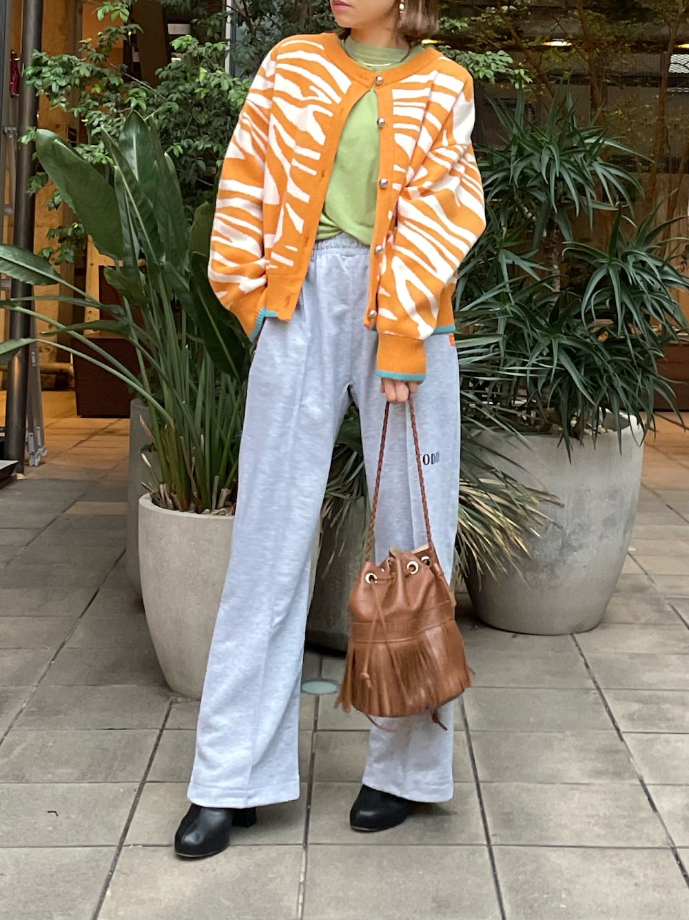 イエロー系のカーディガン/ボレロ、グレー系のスウェットパンツを着用したレディースの冬コーディネートの1枚目の写真