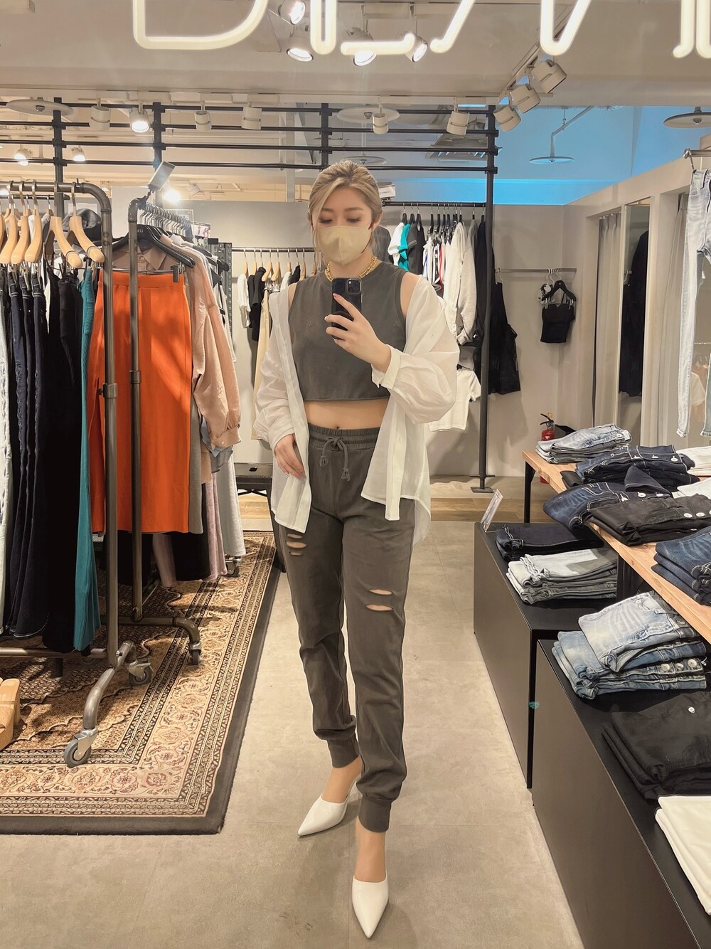 グレー系のタンクトップ、ホワイト系のシャツ/ブラウス、グレー系のスウェットパンツを着用したレディースの春コーディネートの1枚目の写真