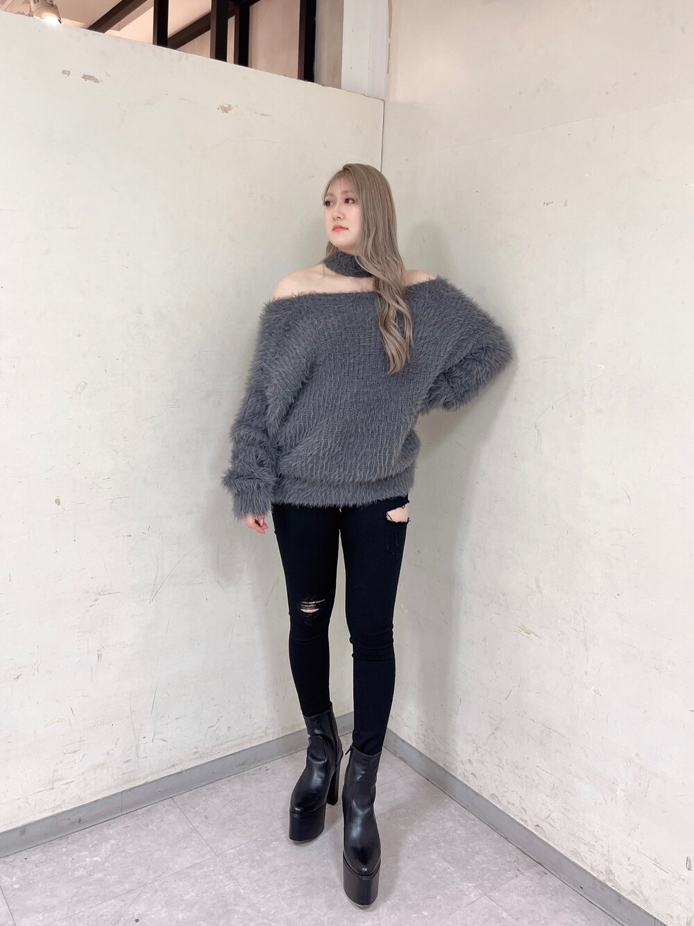 グレー系のニット/セーター、ブラック系のブーツ、ブラック系のデニムパンツを着用したレディースの冬コーディネートの1枚目の写真