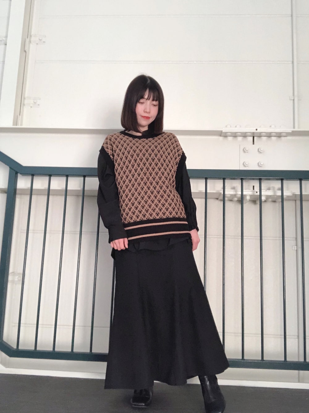 ブルー系のベスト、ブラック系のシャツ/ブラウス、ブラック系のスカートを着用したレディースの冬コーディネートの1枚目の写真