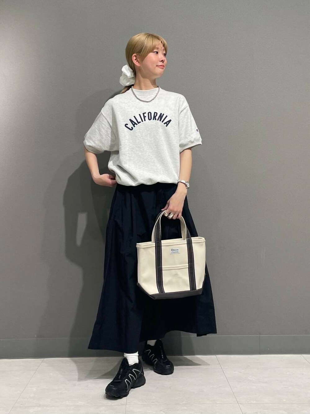 ブラック系のスカート、ホワイト系のヘアゴムを着用したレディースの春コーディネートの1枚目の写真