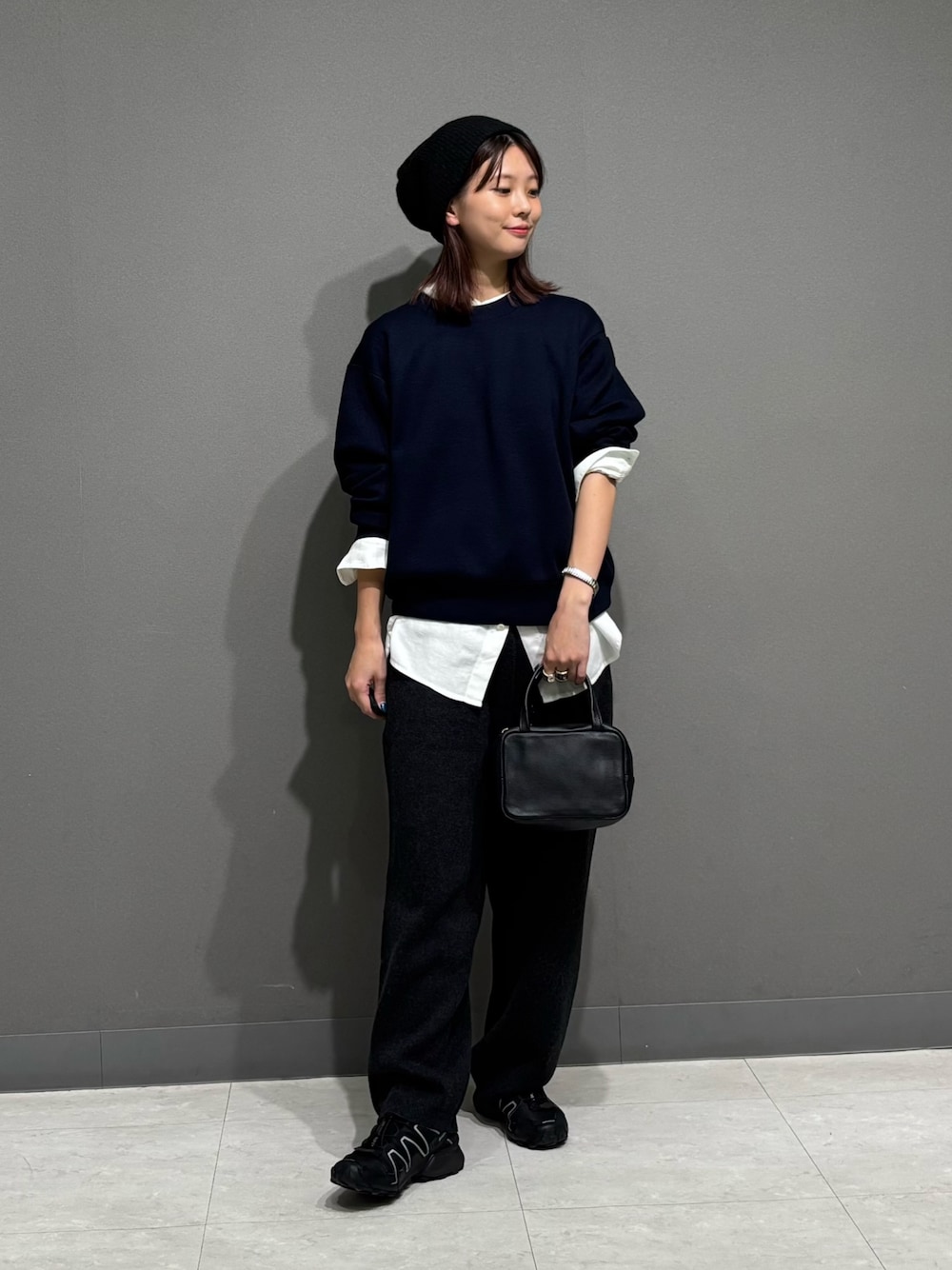 ブルー系のニット/セーター、ホワイト系のシャツ/ブラウス、グレー系のその他パンツを着用したレディースの秋コーディネートの1枚目の写真