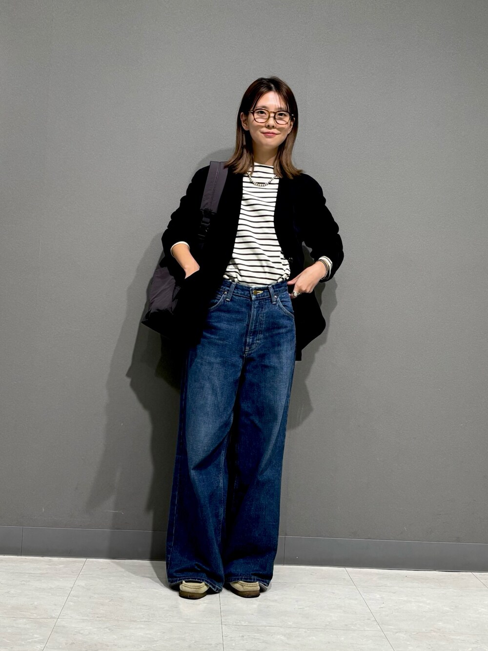 ブラック系のTシャツ/カットソー、ブラック系のノーカラージャケット、グレー系のバックパック/リュックを着用したレディースの秋コーディネートの1枚目の写真