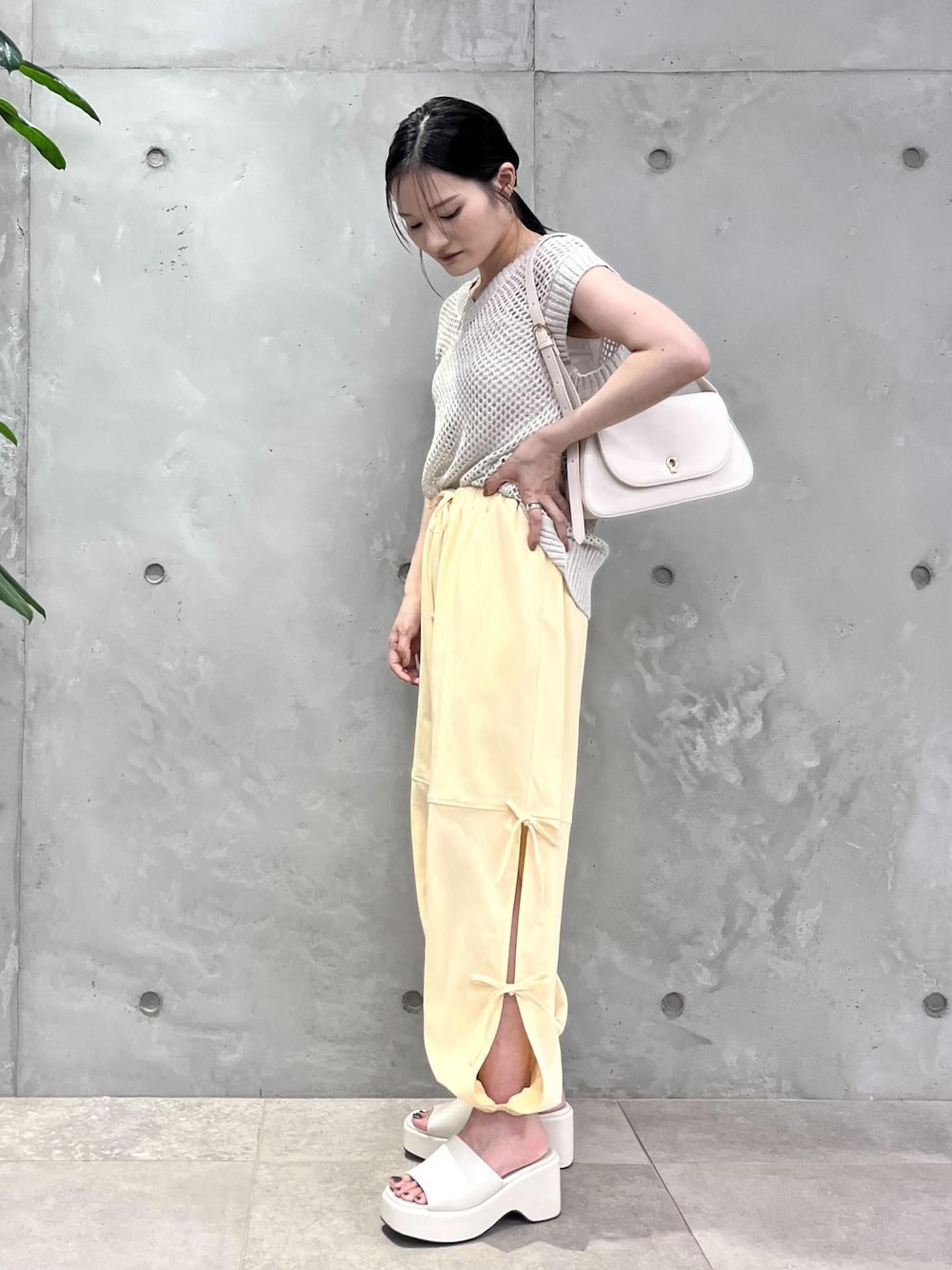 ホワイト系のショルダーバッグ、ホワイト系のサンダル、ホワイト系のベストを着用したレディースの夏コーディネートの1枚目の写真